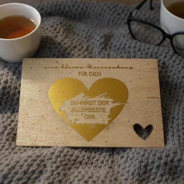 Holz‑Rubbelkarte zur Schwangerschaftsverkündung mit goldenem Rubbelherz.